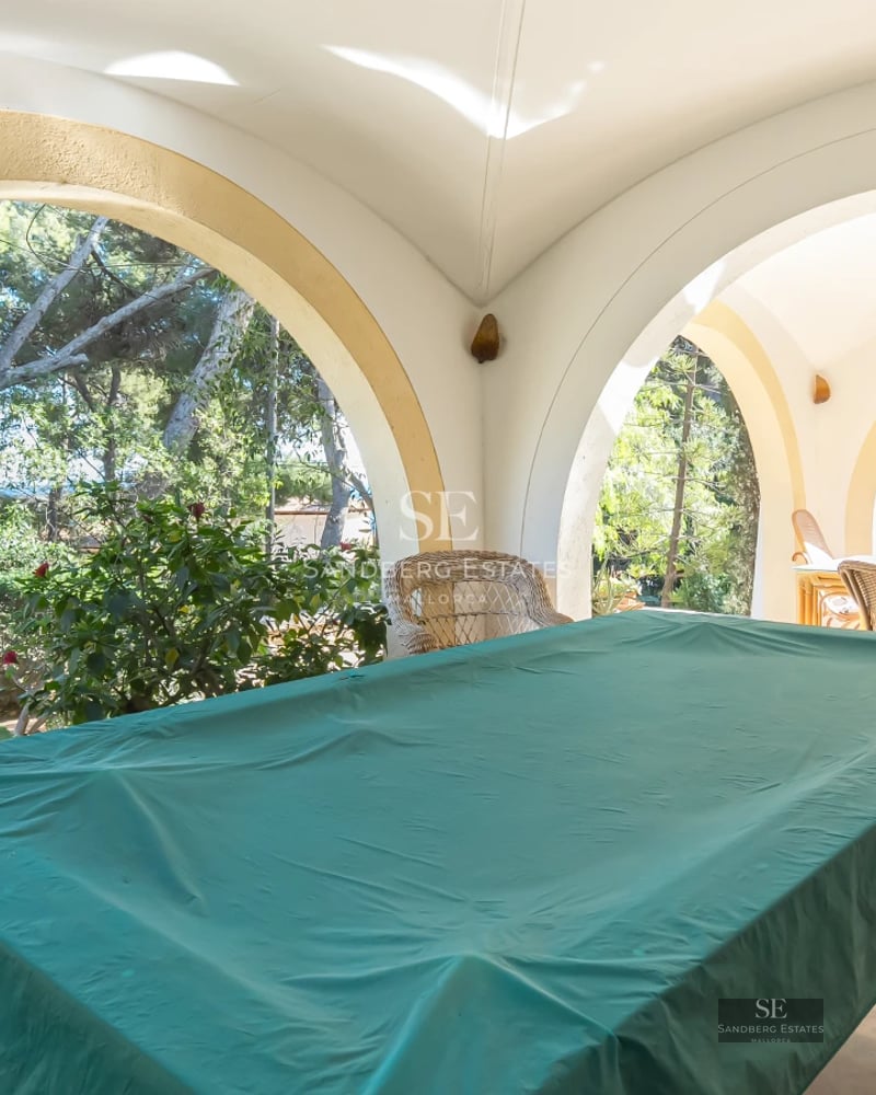 Aerial view of a modern villa with an infinity pool, lush garden, and minimalist architecture. Elegant design and spacious areas.