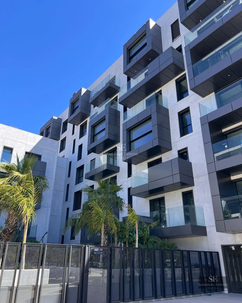Bright living room with large windows offering panoramic sea views. Modern design, elegant furniture and wooden floor.