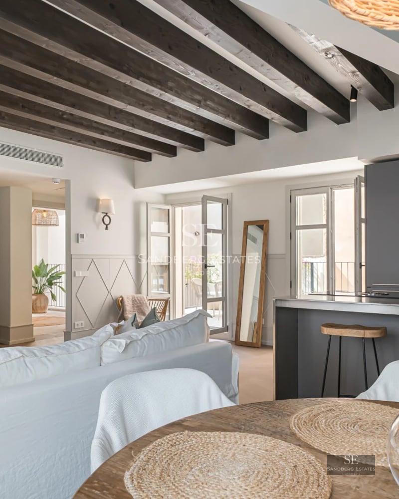 Property view with infinity pool, lush garden, and modern architecture. Warm lighting, sun loungers, and outdoor seating area.