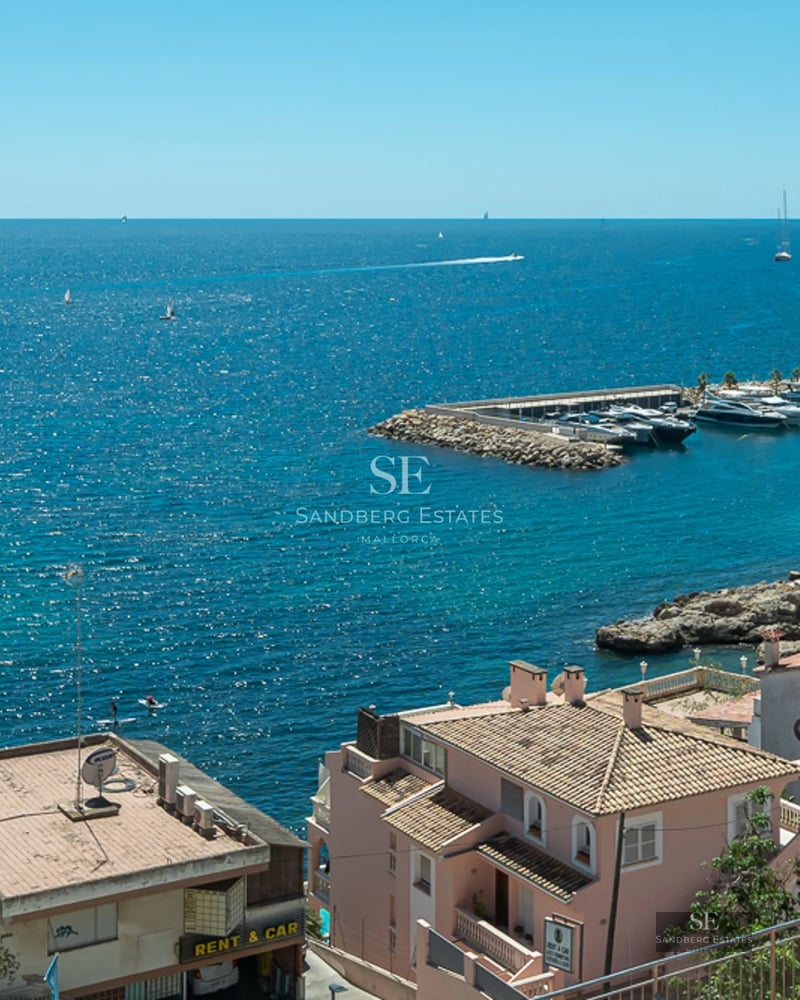 Bright living room with balcony and sea view. Designer sofa, modern coffee table, minimalist decor. Large windows and natural light.