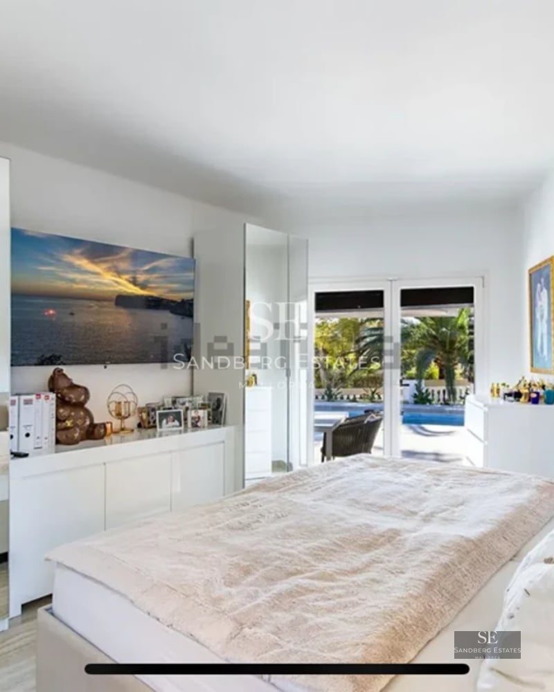 Spacious living room with panoramic windows, light wood flooring, fireplace, and modern design. Natural lighting and garden views.