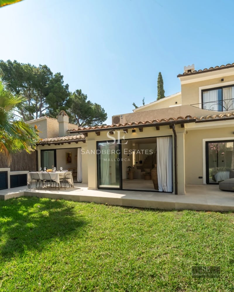 Bright living room with large windows, light wood flooring, white sofas, and panoramic sea views. Modern and elegant design.