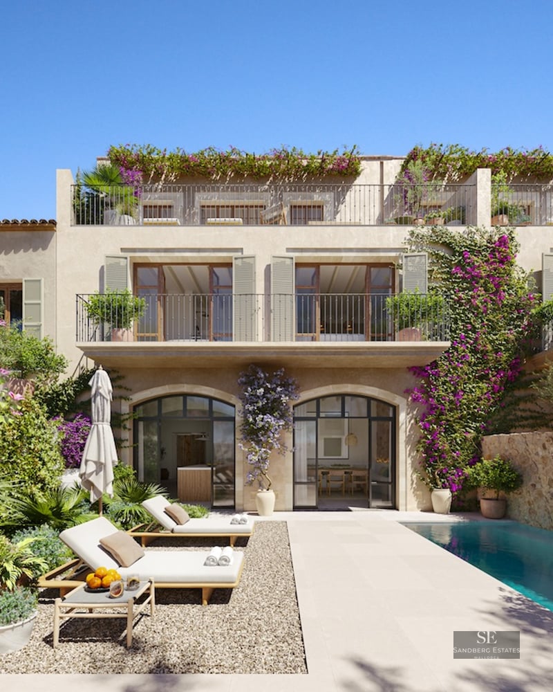 Luxury pool area with sun loungers, stone facade, and vibrant purple bougainvillea climbing the walls.