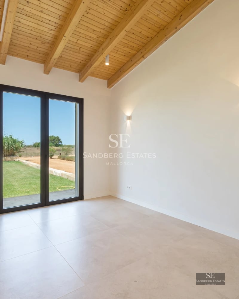 View of modern infinity pool, sun loungers, and minimalist architecture. Large windows reflect sunlight.