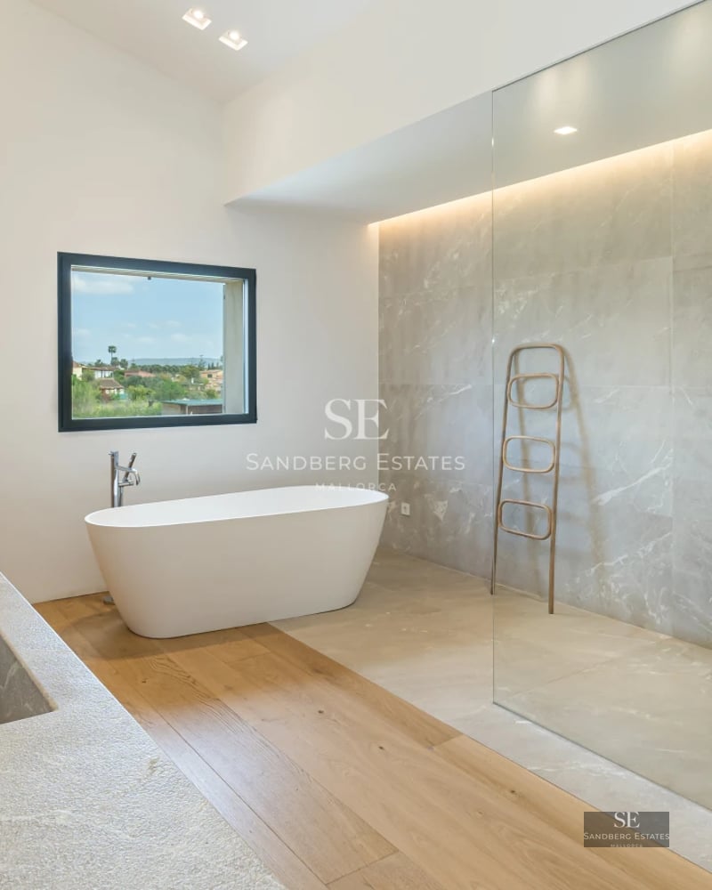 Spacious living room with panoramic sea view windows, beige sofas, light carpet and modern decor. Natural lighting and stunning views.