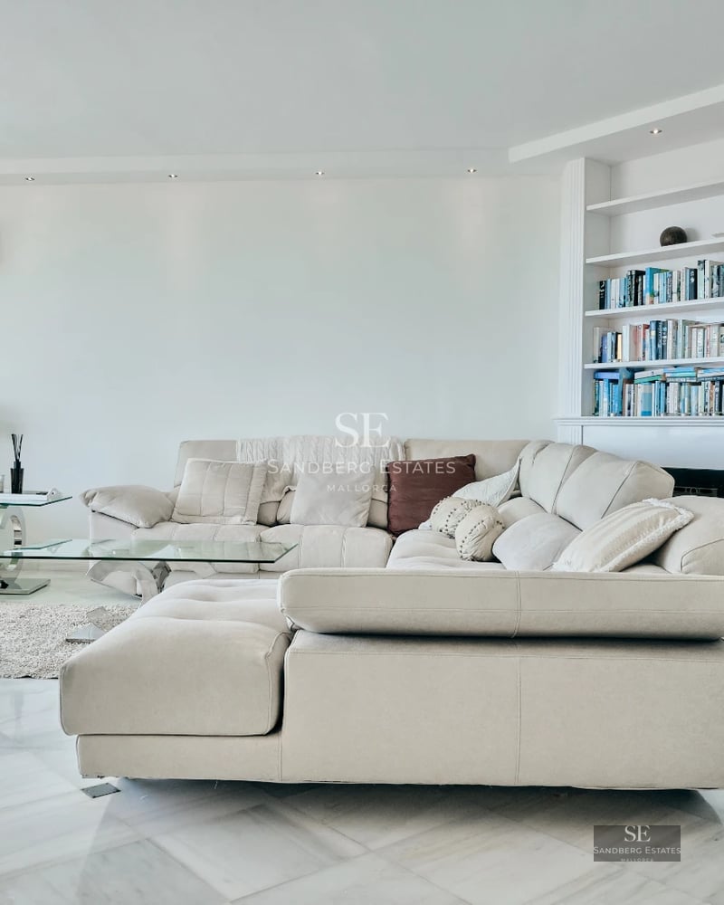 Bright interior with modern design, light wood floors, and large windows. Minimalist decor in neutral tones.