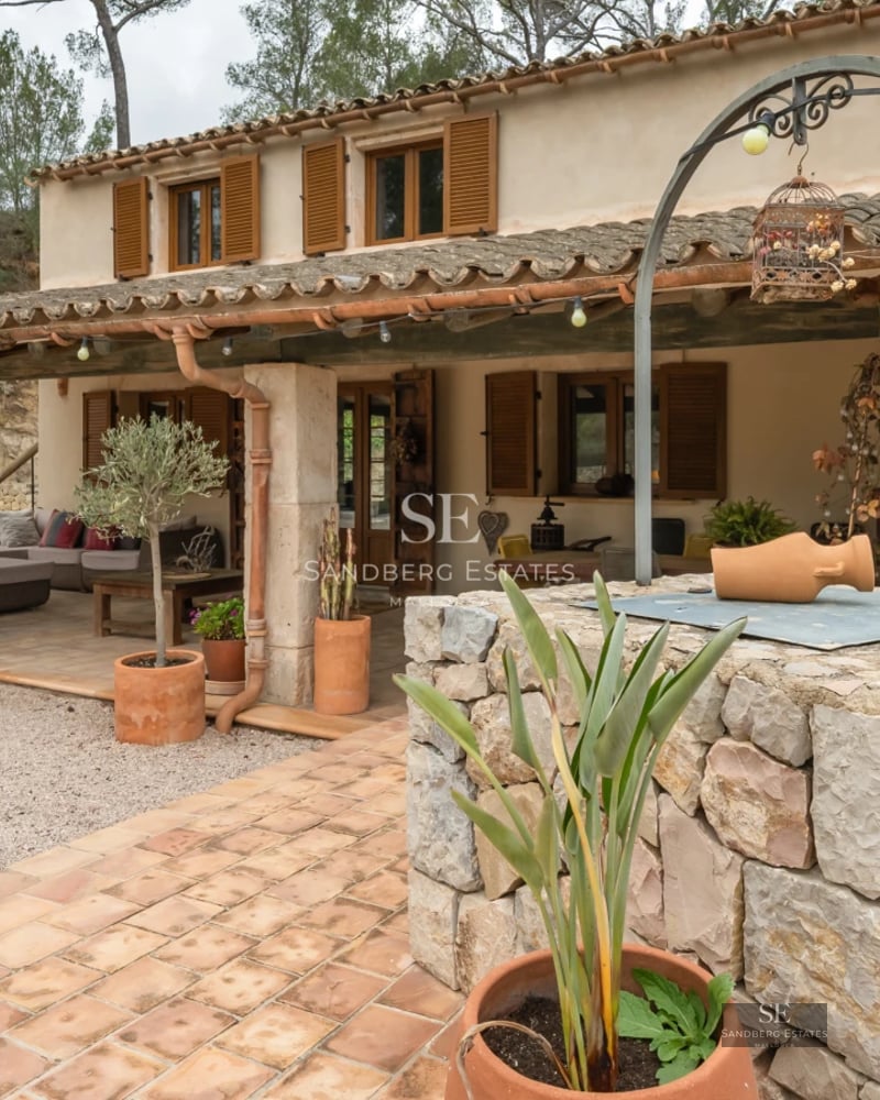 Exterior view of modern villa with infinity pool, lush garden and minimalist architectural design. Stone details and large windows.