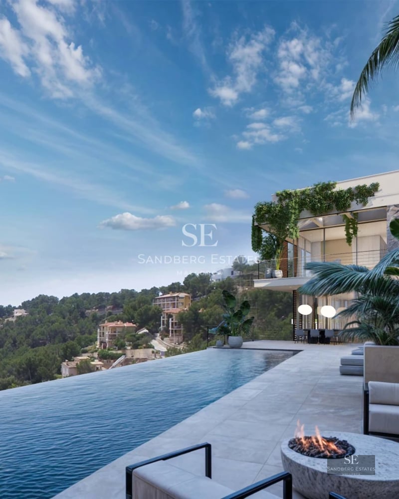 View of an infinity pool with sun loungers and a modern villa featuring large windows. Lush vegetation and clear sky.