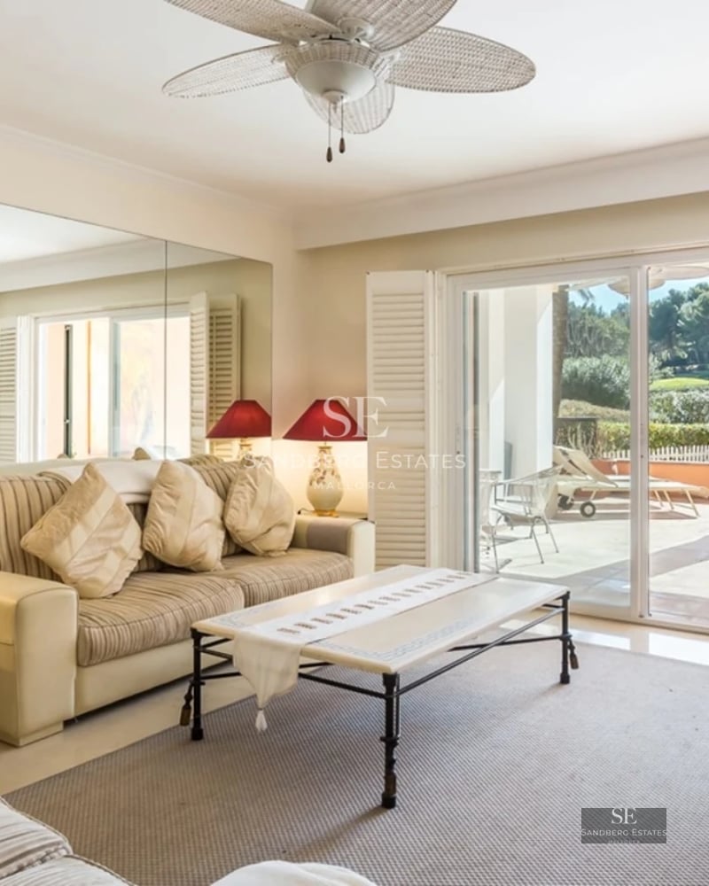 Spacious balcony with sea view, glass railing, wooden floor, outdoor seating area. Modern and elegant design.