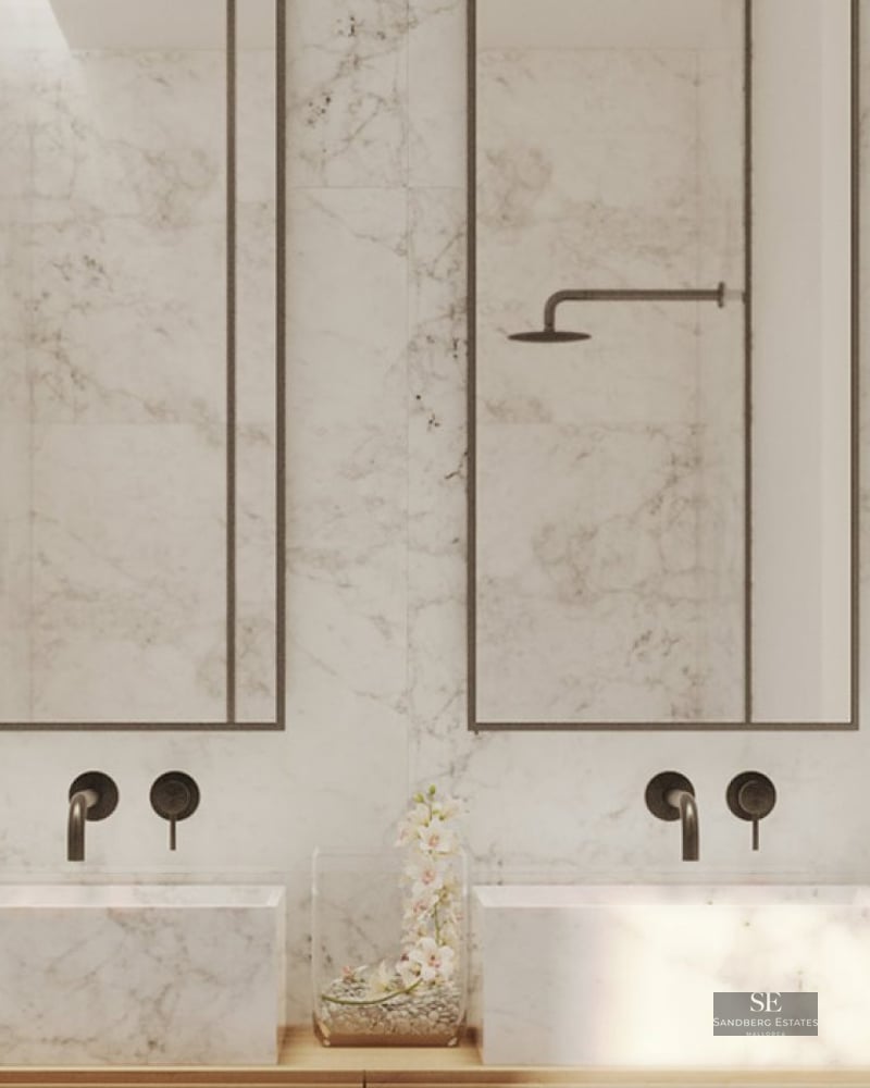 Modern master bathroom with two white marble vessel sinks, matte black wall-mounted faucets, and tall mirrors.