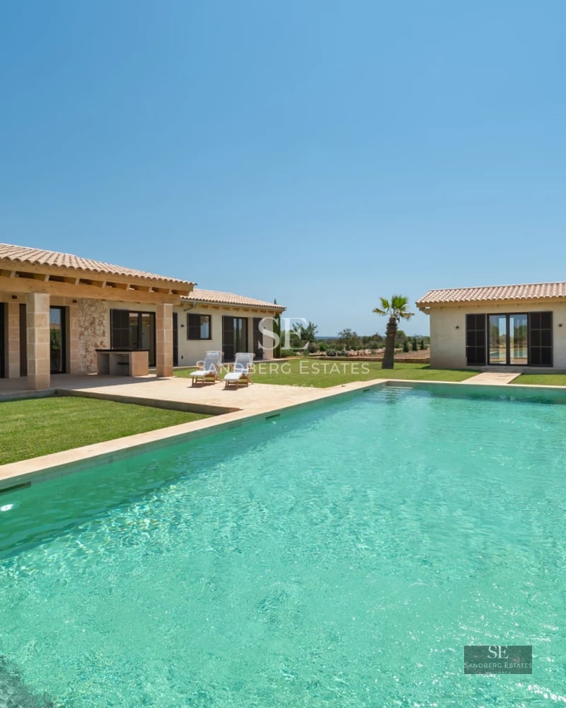 Exterior view of a modern villa with an infinity pool, lush garden and spacious terraces. Minimalist architectural design with high-end finishes.