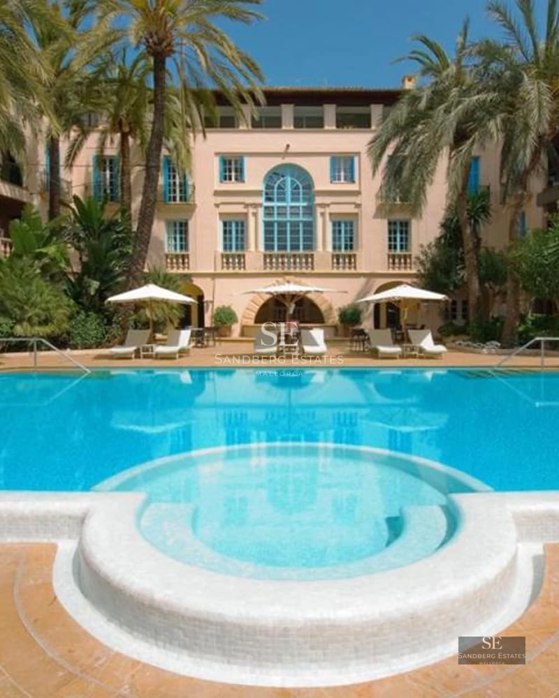 Spacious balcony with panoramic sea views. Modern furniture, glass railing, wooden floor, and retractable awning. Elegant and bright design.