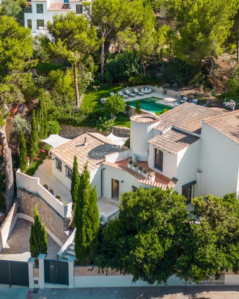 Exterior view of modern villa with infinity pool. Minimalist architecture, large windows, lush landscaping. Warm lighting.
