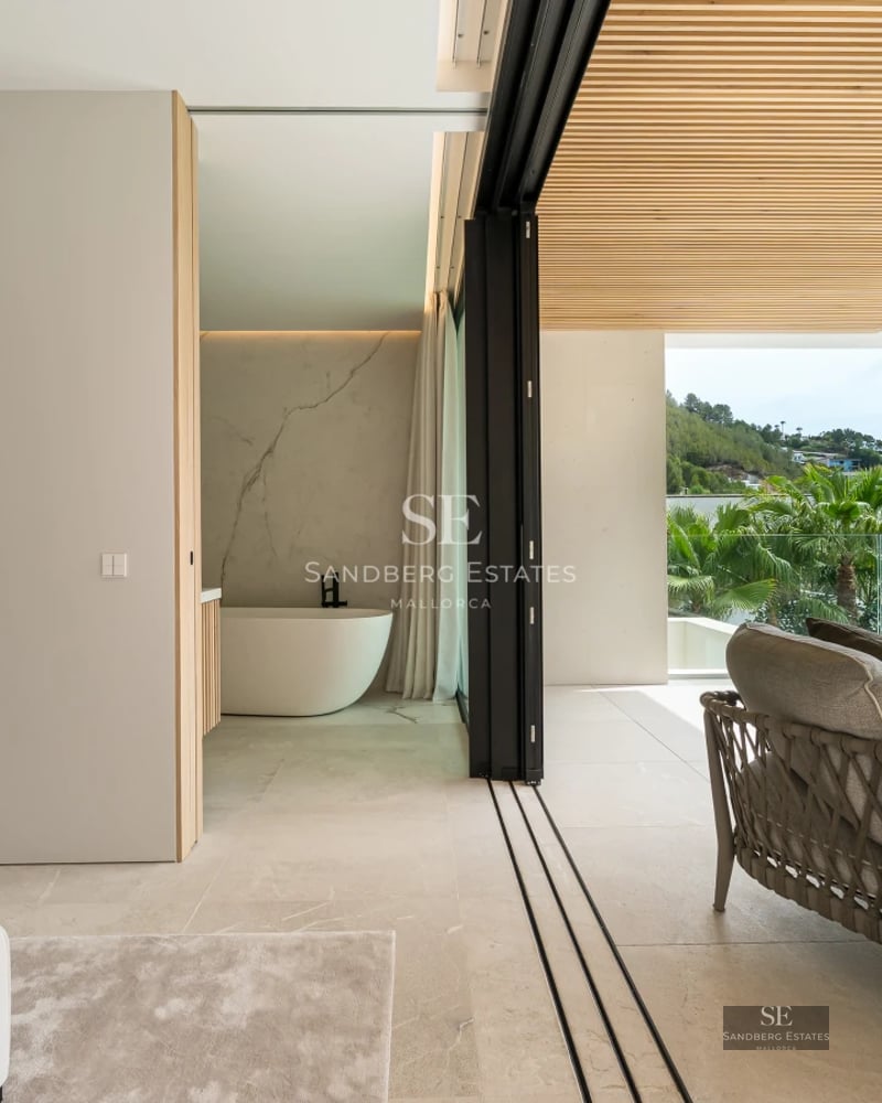 View of reflective pool with modern, minimalist design. Glass and stone facade. Lush landscaping.