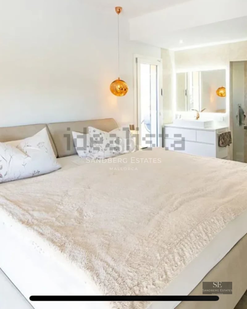 Bright living room with large windows, modern sofa, designer rug, and panoramic sea views. Elegant and minimalist decor.