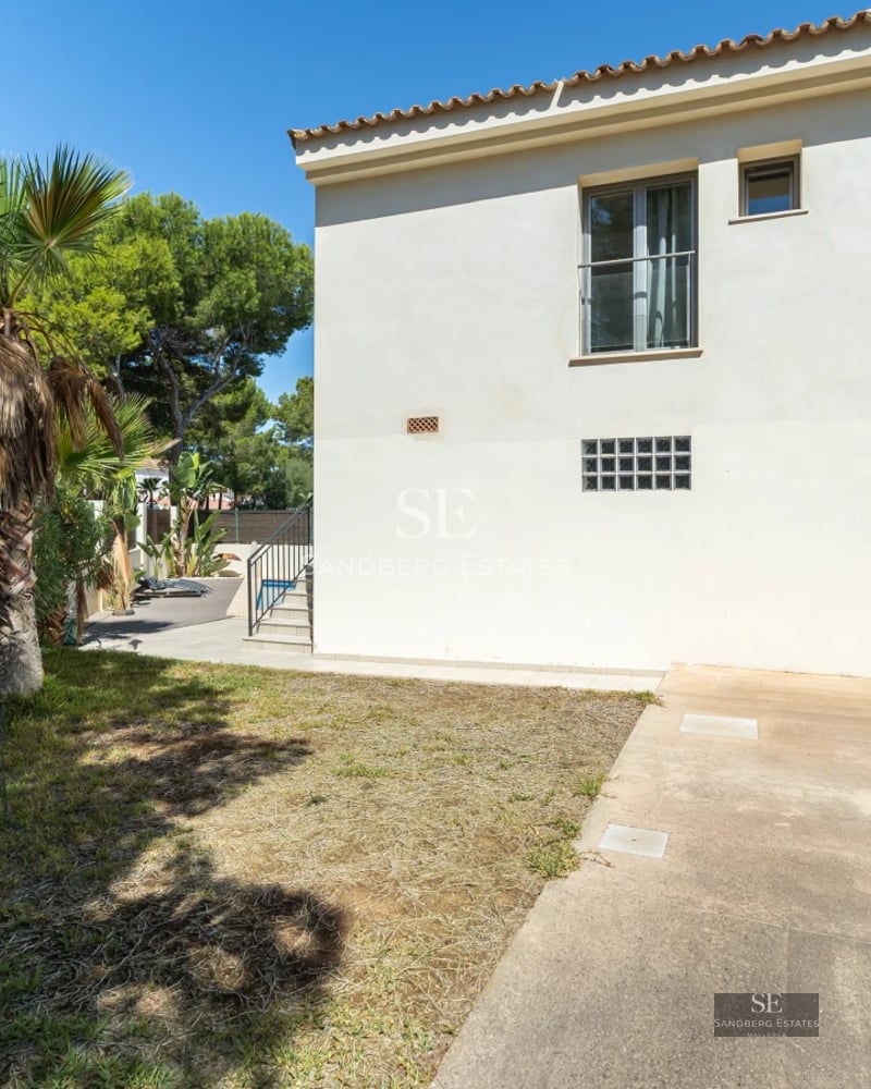 Expansive garden with blue pool, lounge chairs and lush greenery. Modern architecture with large windows and terrace.