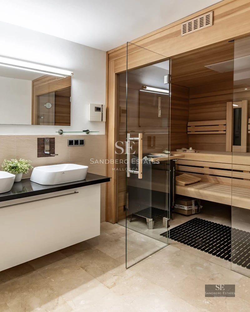 Large reflecting pool with modern architecture. Stylish outdoor furniture. Warm ambient lighting. Lush vegetation.