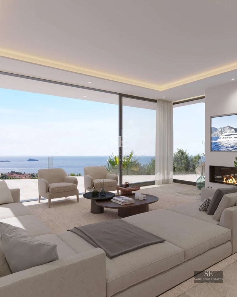 View of infinity pool with sun loungers and lush vegetation. Modern architecture with large glass windows and minimalist design.