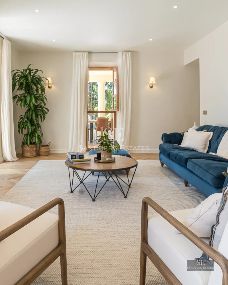 View of an elegant pool with sun loungers and umbrellas. Modern architecture with large windows and lush vegetation surrounding it.