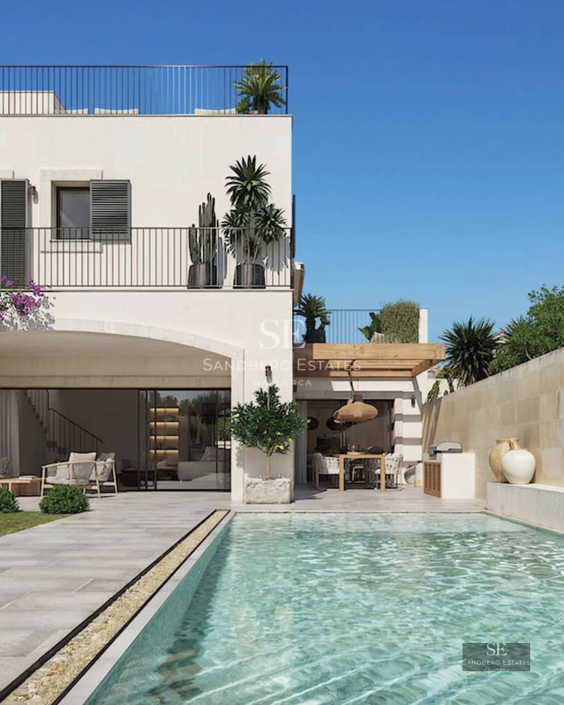 View of infinity pool and lush garden of a modern villa with large windows and minimalist design. Warm sunset glow.