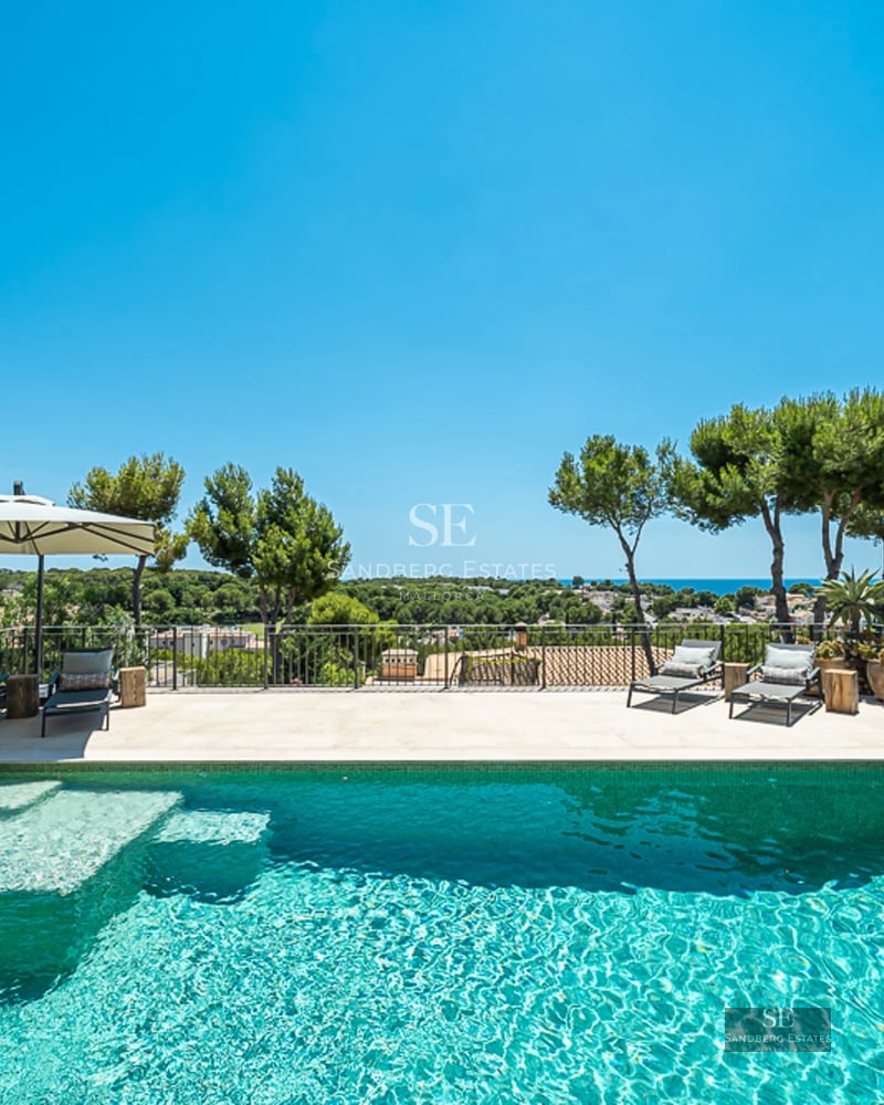 Vue extérieure d'une villa moderne avec piscine, jardin luxuriant et conception architecturale minimaliste avec de larges fenêtres.