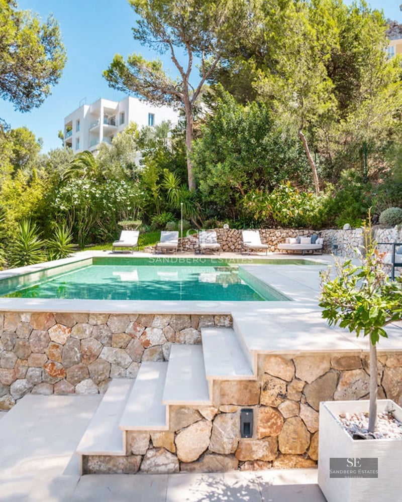 Exterior of modern villa with infinity pool, lush garden, and large windows. Minimalist design and panoramic views.