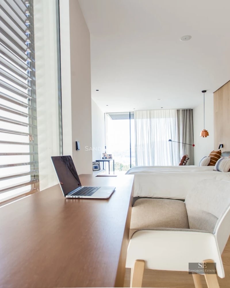 Spacious living room with modern fireplace, large windows, and terrace view. Minimalist and elegant design.