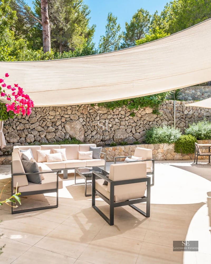 View of a modern villa featuring an infinity pool, expansive terraces, and sea views. Minimalist architecture and sleek design.