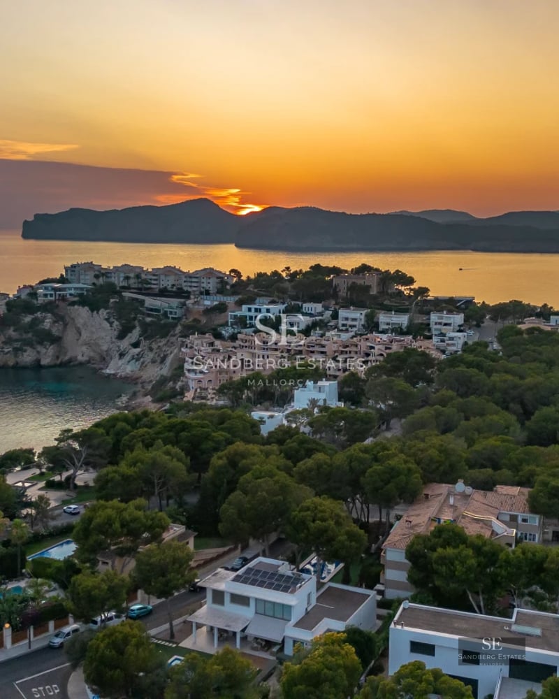 View of a modern villa with infinity pool. Minimalist design, large windows, and lush gardens. Luxurious and tranquil atmosphere.