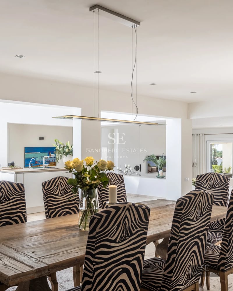 Spacious living room with large windows, light wood floor, modern furniture, and balcony access with panoramic views.