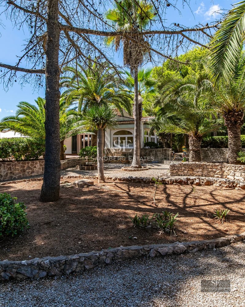 Exterior view of a modern villa with infinity pool, expansive terraces, panoramic windows, and minimalist landscape design.