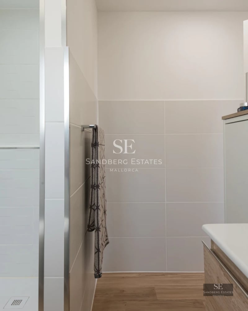 View of a modern swimming pool bordered by lawn and lush greenery. Minimalist architecture and relaxing atmosphere.