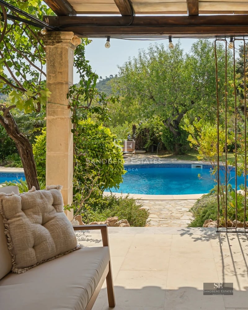 Exterior view of a modern villa featuring an infinity pool, lush gardens, and spacious terraces. Contemporary architectural design.