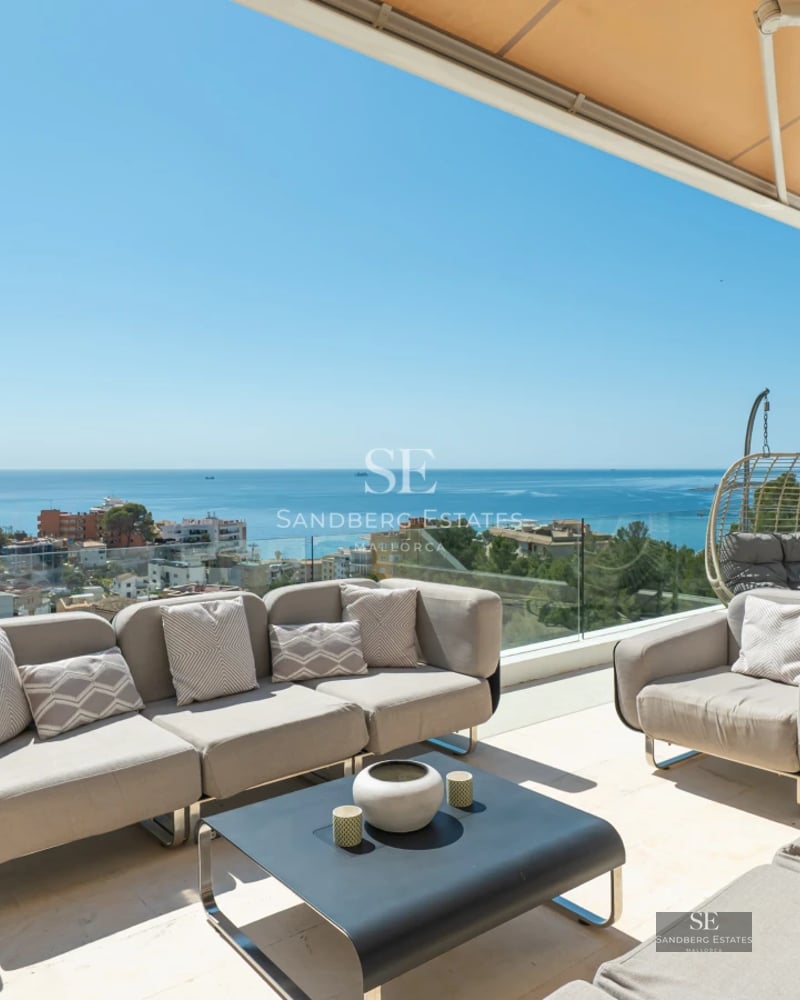Exterior of modern villa with reflecting pool, minimalist design, large windows, and lush vegetation.