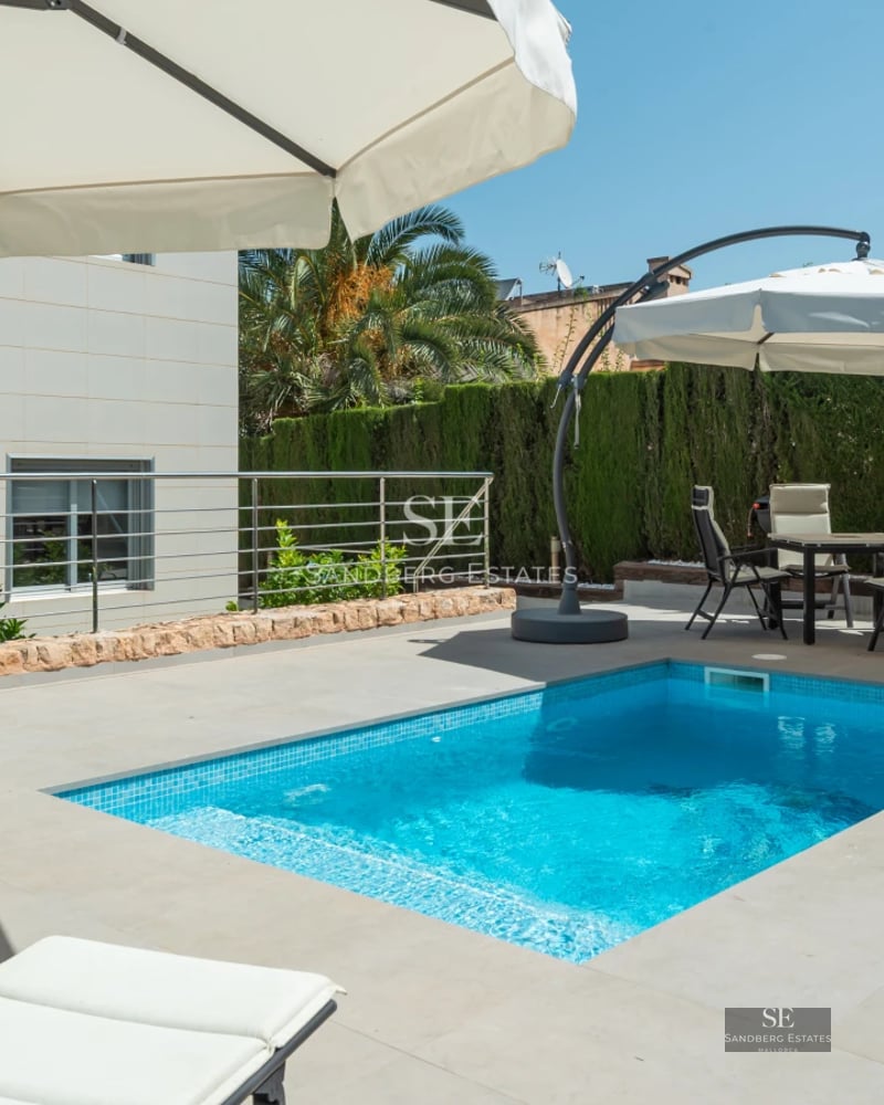 Exterior view of modern villa with infinity pool and outdoor living area. Minimalist design and panoramic views.