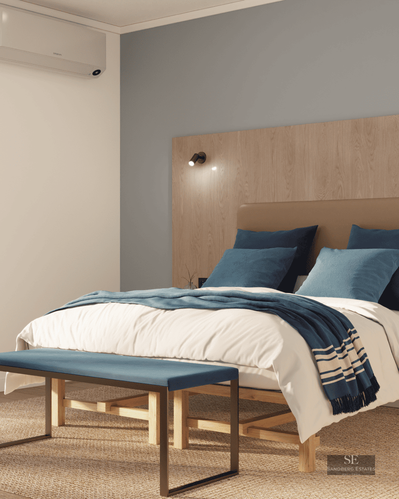 Chambre lumineuse avec lit double, tête de lit en bois et accès à un balcon ensoleillé.