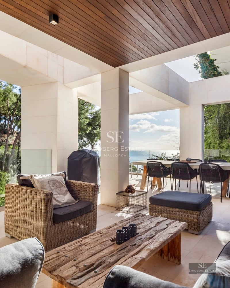 View of infinity pool, spacious terrace with sun loungers, modern architecture, lush landscaping and panoramic views.