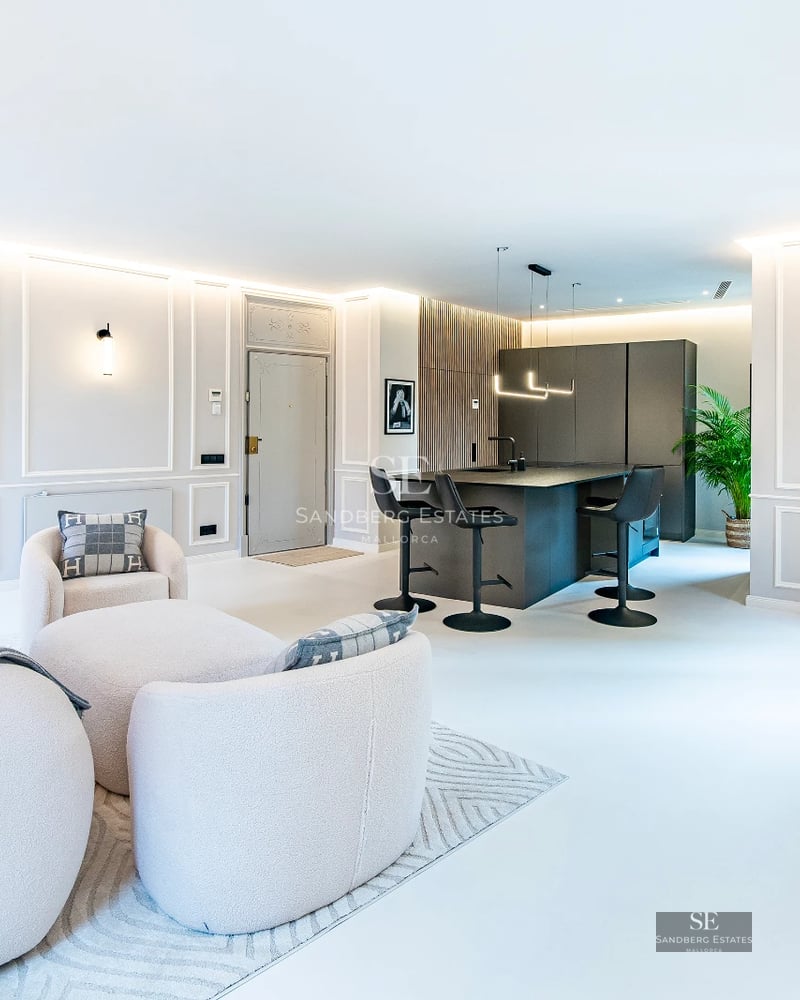 View of the infinity pool with glass edge, surrounded by cream-colored tiles. Modern, minimalist architecture with ocean views.