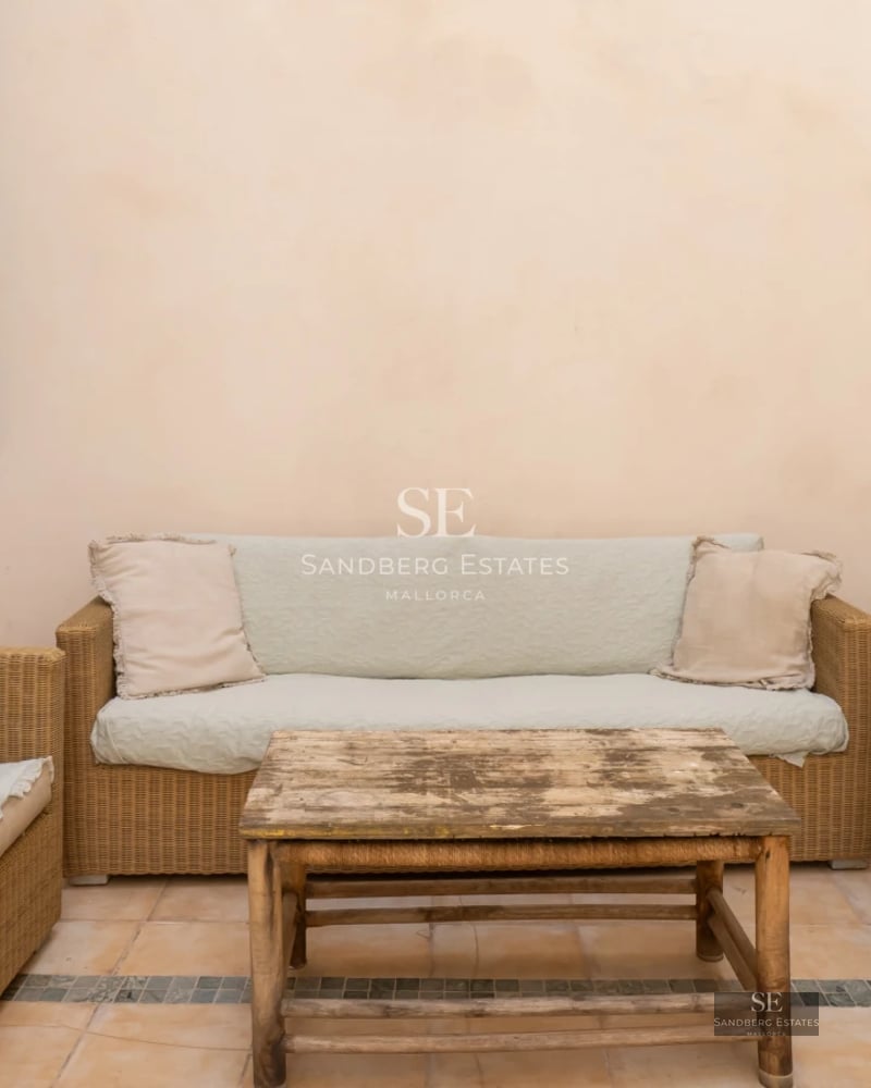 View of a modern pool surrounded by lush greenery and a house with large windows. Contemporary design and relaxing atmosphere.