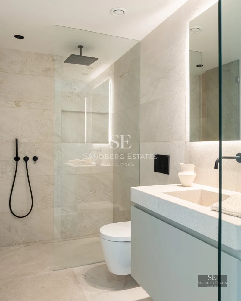 Large pool with sun loungers, surrounded by lush vegetation. Modern architecture with large windows. Luxurious and relaxing outdoor space.