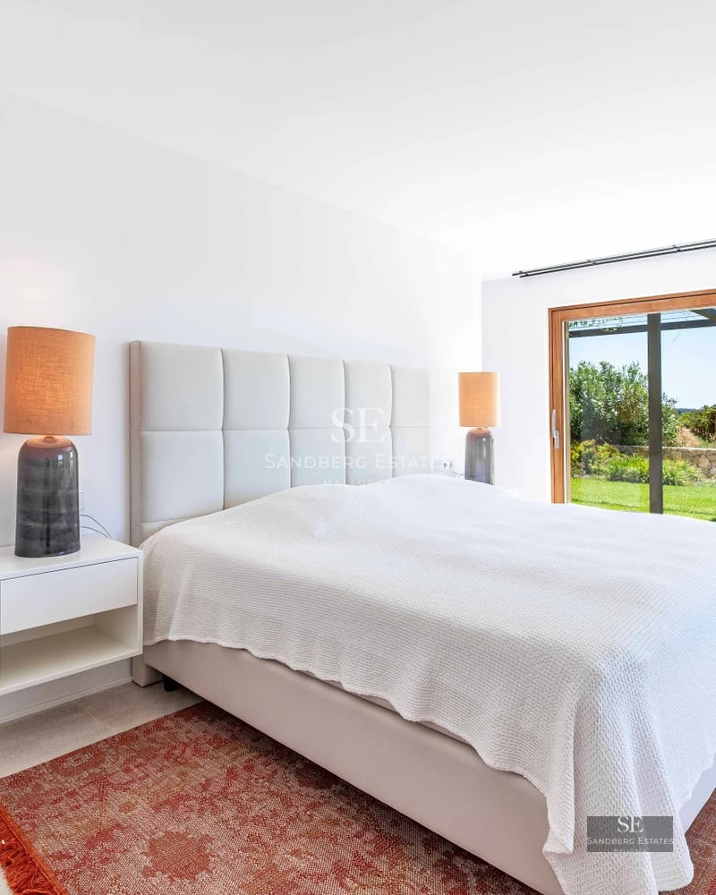 Spacious living room with sea views through panoramic windows. Modern design, light wood floors, neutral sofas, and minimalist decor. Natural lighting.