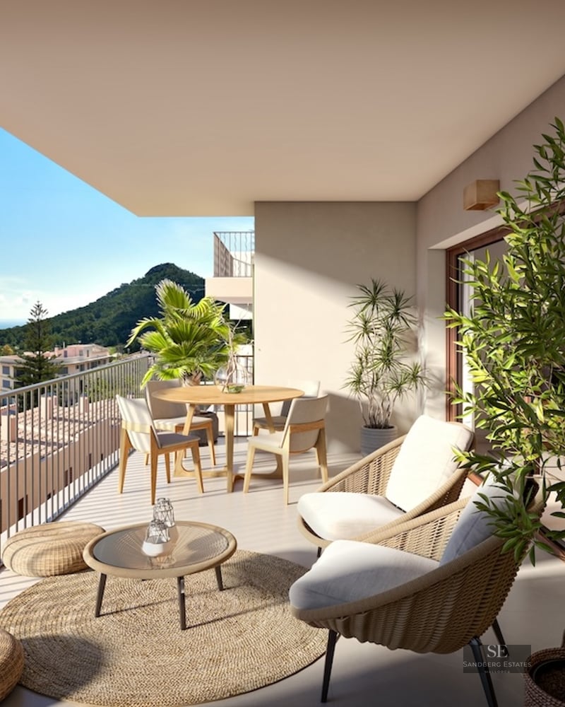 Spacious terrace featuring wicker furniture, outdoor dining area, and panoramic views of the sea and mountains.