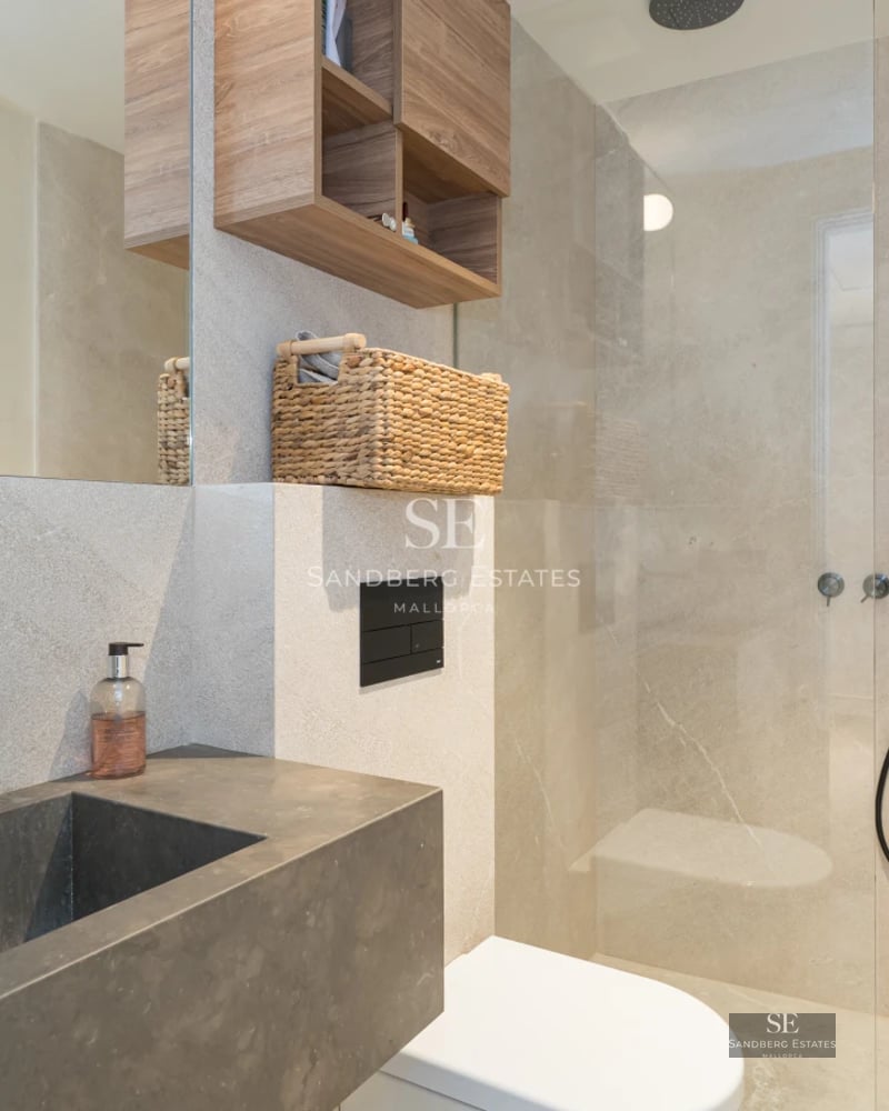 Aerial view of a modern villa with an infinity pool, surrounded by lush greenery and featuring spacious terraces.