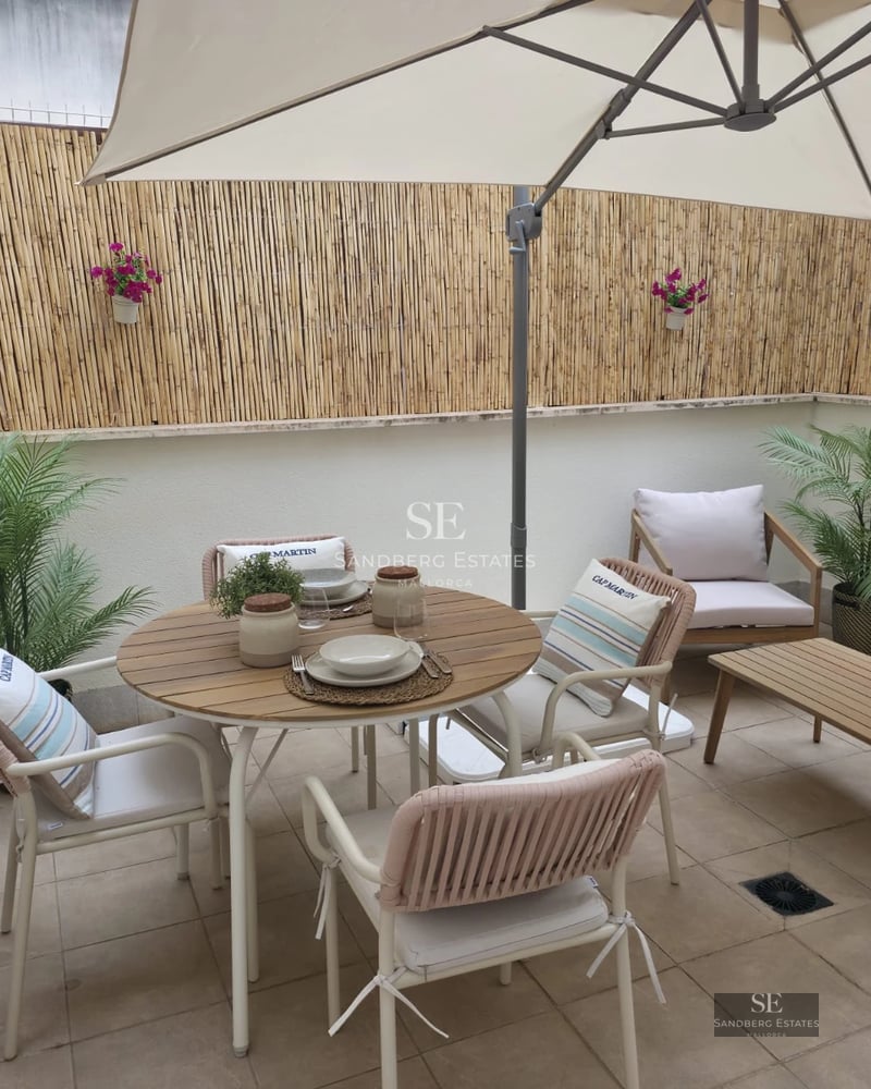 Spacious living room with floor-to-ceiling windows, light wood floors, modern gray sofa, and access to pool terrace. Minimalist, bright design.