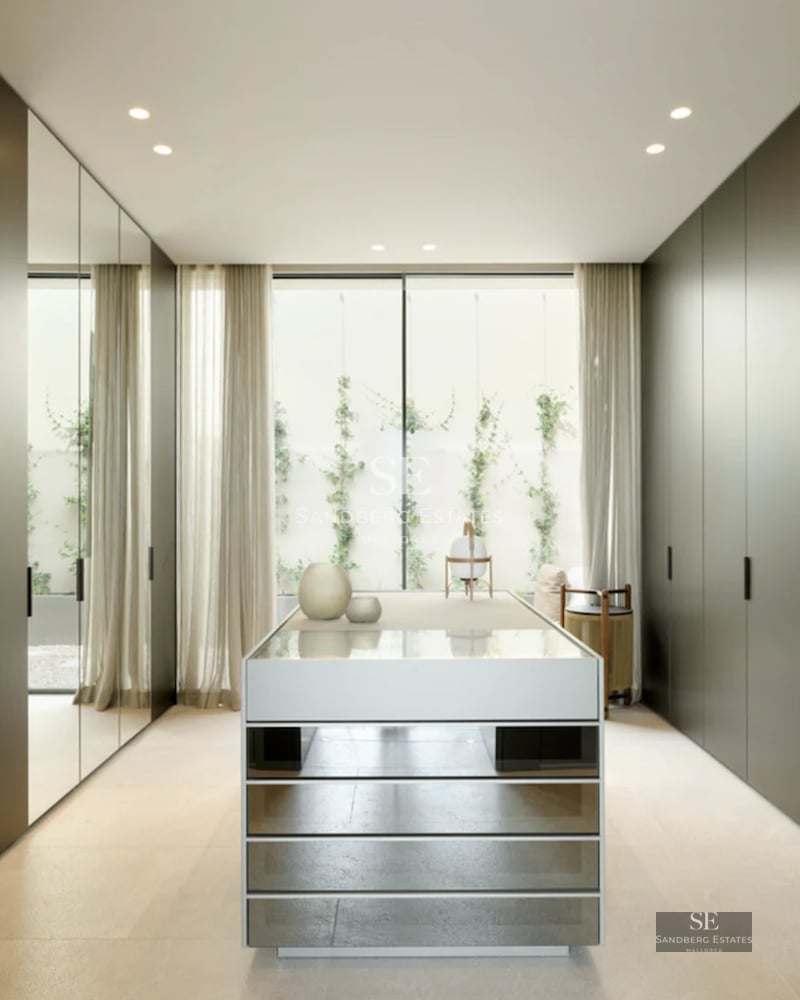 Spacious living room featuring floor-to-ceiling windows, light wood floors, modern fireplace, and designer sofas. Panoramic views.