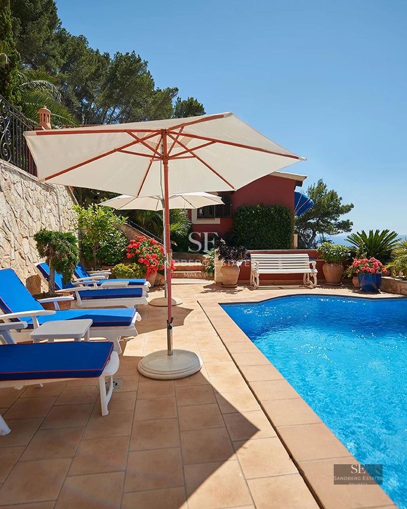 Spacious living room with floor-to-ceiling windows, sparkling pool, modern design, and natural light. Luxurious finishes and designer furniture.