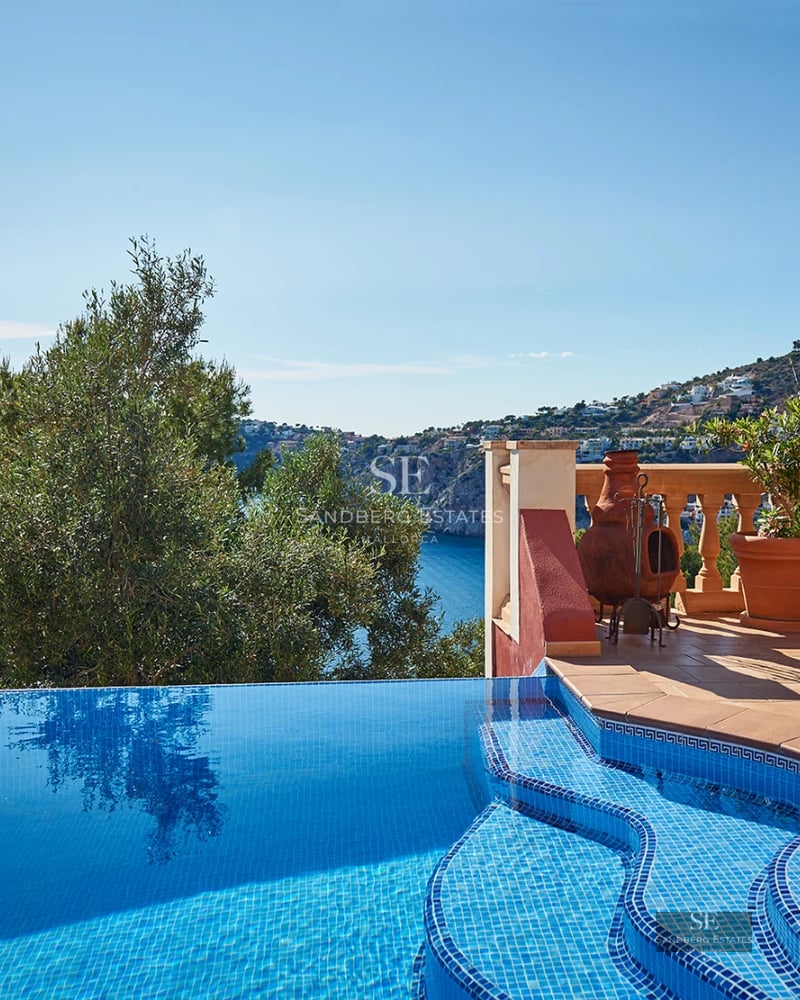 Spacious terrace with sea view. Modern design, elegant furniture, wooden floor, and glass railing. Bright and relaxing atmosphere.