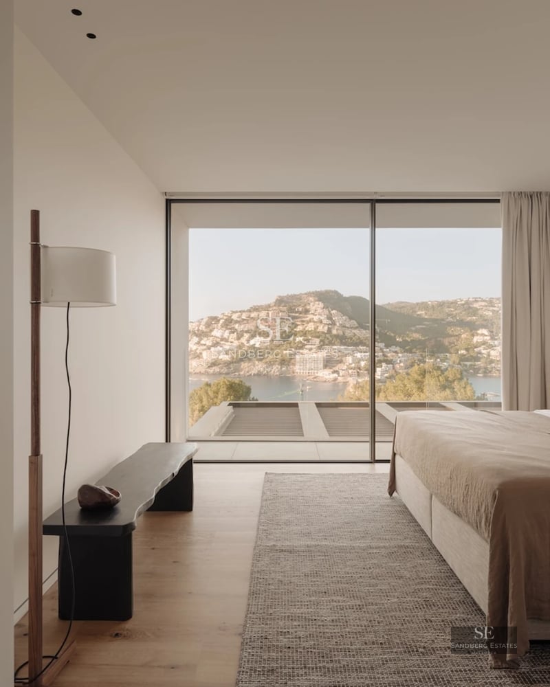 Spacious living room with panoramic windows, modern fireplace, and minimalist decor. Natural light highlights wood and stone textures.