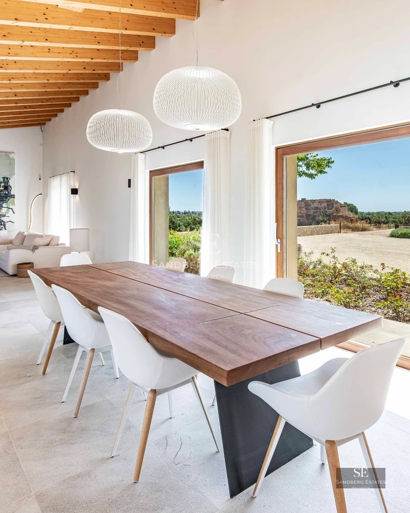 View of a modern villa with infinity pool and garden. Minimalist architecture with large windows. Palm trees and outdoor furniture.