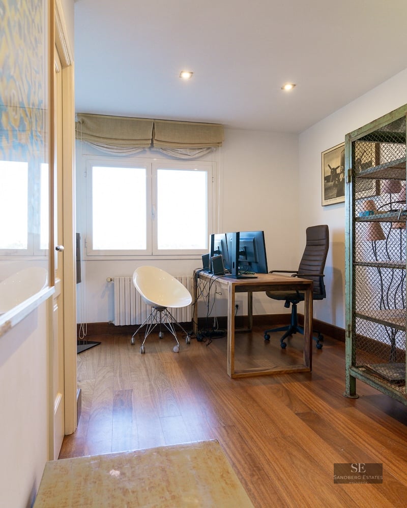 Home office with wood floors, desk with dual monitors, and a vintage green metal mesh cabinet.